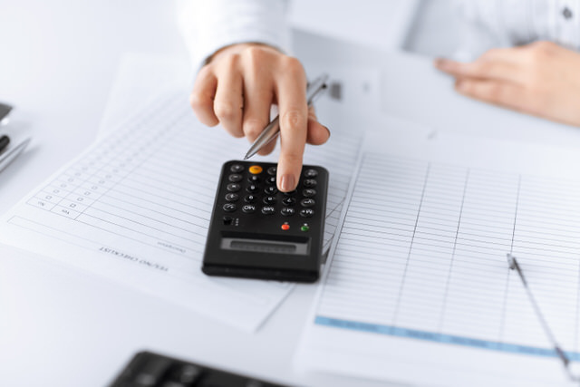 woman hand with calculator and papers